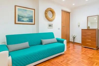 a living room with a blue couch and a dresser at Hi HOME in Rome