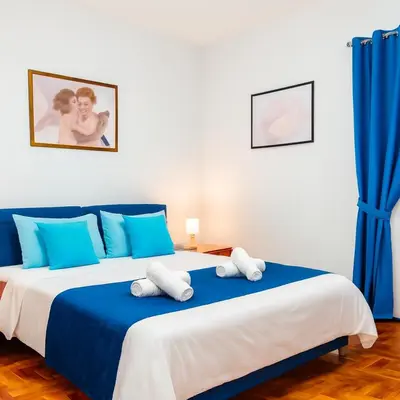 a bedroom with a large bed with blue and white pillows at Hi HOME in Rome