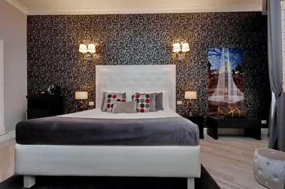 a bedroom with a white bed and a wall at Sistina Twentythree luxury rooms in Rome