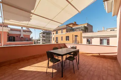 a balcony with a table and chairs on a roof at GuestHost - Terrace Apartment Nomentano - Roma in Rome
