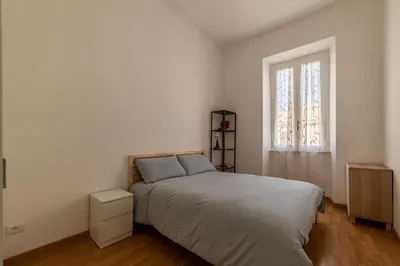 a bedroom with a bed and a desk and a chair at GuestHost - Terrace Apartment Nomentano - Roma in Rome
