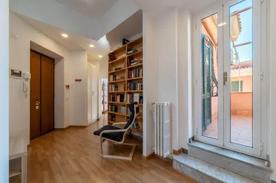 a book shelf in a room with a window at GuestHost - Terrace Apartment Nomentano - Roma in Rome