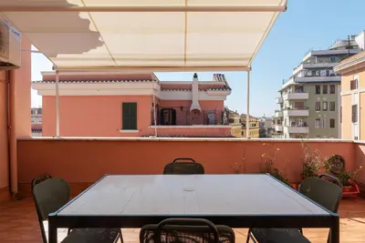 a kitchen with a table and chairs in a room at GuestHost - Terrace Apartment Nomentano - Roma in Rome