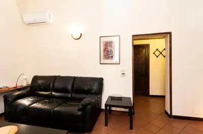 a living room with a leather couch and a table at Secret place in the heart of ancient Trastevere in Rome