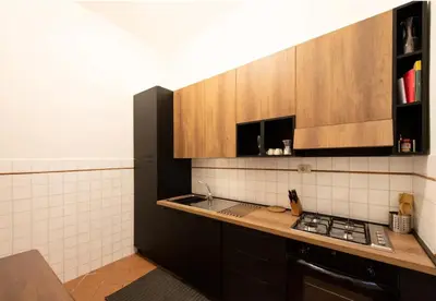 a kitchen with wooden cabinets and a counter top at Secret place in the heart of ancient Trastevere in Rome