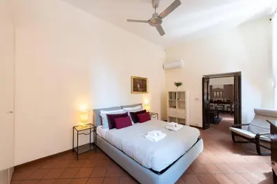 a bedroom with a bed and a living room at Secret place in the heart of ancient Trastevere in Rome
