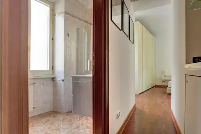 a hallway with a door open to a living room at Colosseo Green Park - Home and More in Rome