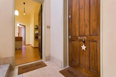 a door leading to a hallway with a welcome sign on it at Alice House al Vaticano in Rome