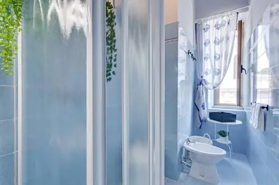 a bathroom with a toilet and a glass shower at Alice House al Vaticano in Rome