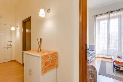 a living room with a small cabinet and a table at Alice House al Vaticano in Rome