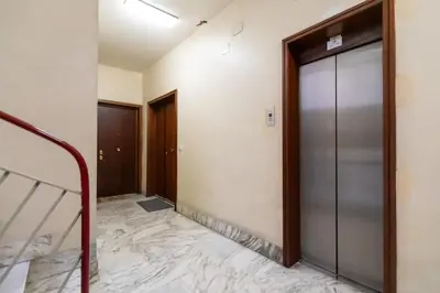 a hallway with a glass door and a marble floor at Appartamento Elegante e Luminoso con Metro Vicina in Rome