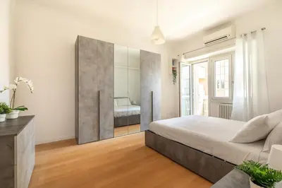 a bedroom with a large bed and a mirror at Appartamento Elegante e Luminoso con Metro Vicina in Rome