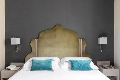 a bedroom with a large bed with two blue pillows at HOTEL ADRIANO Rooftop in Rome