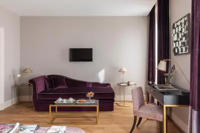 a living room with a purple couch and a table at HOTEL ADRIANO Rooftop in Rome