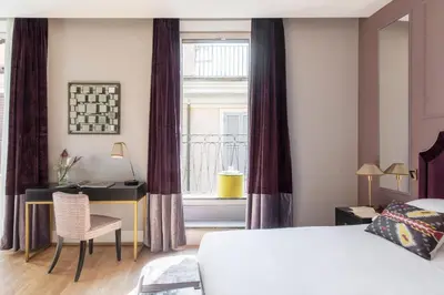 a bedroom with a bed and a desk and a window at HOTEL ADRIANO Rooftop in Rome