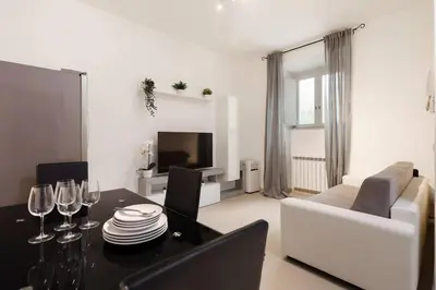 a living room with a table and a white couch at Appartamento Moderno nel Cuore di Roma in Rome