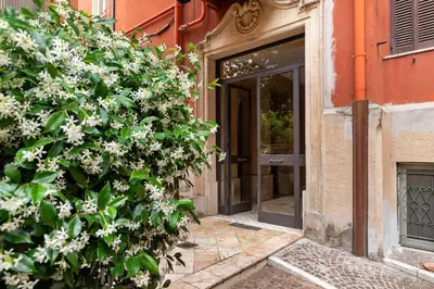 a plant with white flowers in front of a door at Appartamento Moderno nel Cuore di Roma in Rome