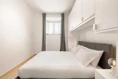 a bedroom with a white bed and a window at Appartamento Moderno nel Cuore di Roma in Rome