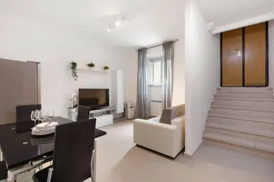 a living room with a table and a dining room at Appartamento Moderno nel Cuore di Roma in Rome