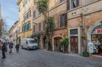 a street with a van parked on the side of a building at Vibrant Trastevere 2 bedrooms on Via del Moro in Rome