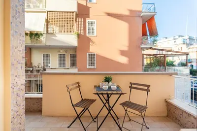 a patio with two chairs and a table on a balcony at San Pietro Appartamento Luminoso e Moderno in Rome