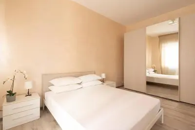 a bedroom with a white bed and a large mirror at San Pietro Appartamento Luminoso e Moderno in Rome