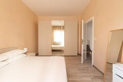 a bedroom with a large white bed and a window at San Pietro Appartamento Luminoso e Moderno in Rome