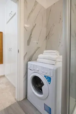 a washer and dryer in a bathroom with a wall at Garbatella Appartamento Moderno Relax e Comfort in Rome