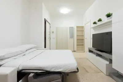 a white room with a bed and a flat screen tv at Garbatella Appartamento Moderno Relax e Comfort in Rome