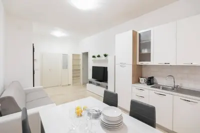 a kitchen and living room with a white table and chairs at Garbatella Appartamento Moderno Relax e Comfort in Rome