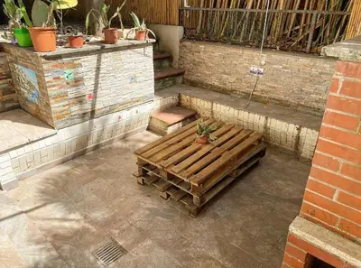 a patio with a wooden bench with a potted plant at Loft with little backyard and patio in Rome