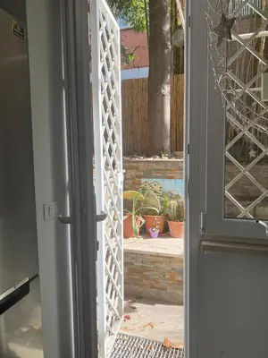 an open door to a patio with potted plants at Loft with little backyard and patio in Rome