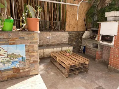 a patio with a wooden bench and a brick oven at Loft with little backyard and patio in Rome