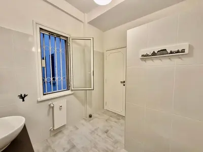 a white bathroom with a sink and a window at Edo's Rhome in Rome