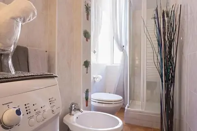 a white bathroom with a toilet and a sink at Aly Apartment in Vatican in Rome