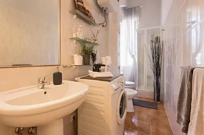 a white bathroom with a sink and a toilet at Aly Apartment in Vatican in Rome
