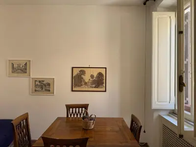 a dining room with a wooden table and a window at Borgo in Elegante appartamento in Rome
