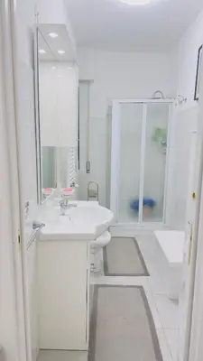 a white bathroom with a sink and a mirror at Marconi House - A un passo da Trastevere in Rome