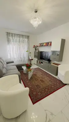 a living room with white furniture and a chandelier at Marconi House - A un passo da Trastevere in Rome