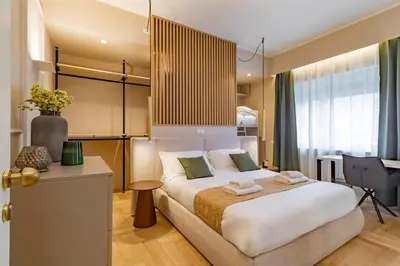 a bedroom with a large white bed and a desk at Cipro Vatican Luxury Escape in Rome