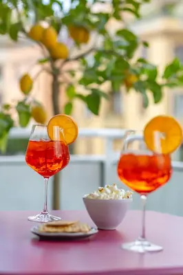 a table with two wine glasses and a bowl of popcorn at Cipro Vatican Luxury Escape in Rome