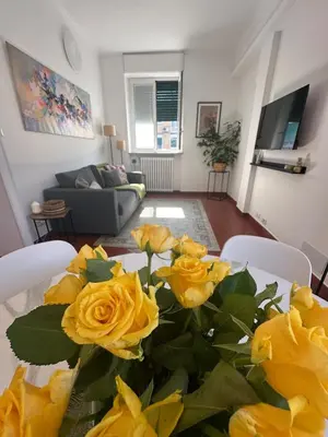 a table with yellow roses on it in a living room at 'Boh House' in Rome