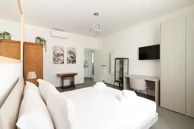 a white bedroom with a white bed and a couch at Gilda's Home in Rome