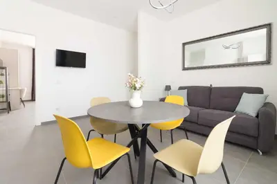 a living room with a table and yellow chairs at Gilda's Home in Rome