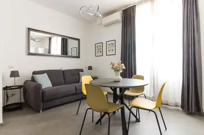 a living room with a couch and a table and chairs at Gilda's Home in Rome