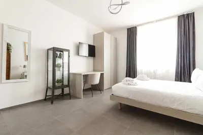 a bedroom with a bed and a desk and a mirror at Gilda's Home in Rome