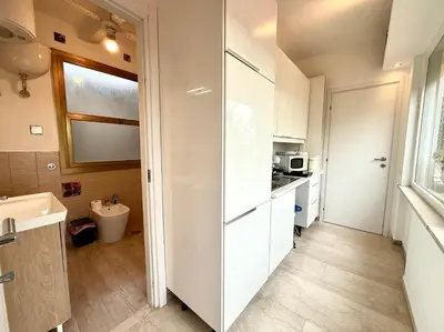 a small kitchen with white cabinets and a sink at Bauhouse in Rome