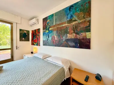a bedroom with a bed and a large painting on the wall at Bauhouse in Rome