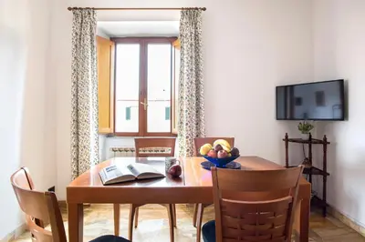 a dining room with a wooden table and chairs at Paramount Penthouse in Rome