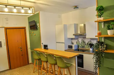a kitchen with a table and green chairs in it at Moletta 17 in Rome